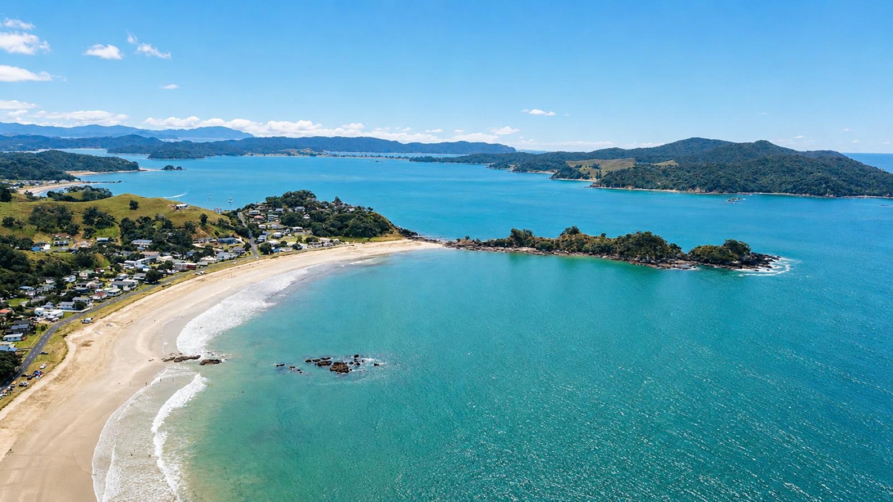 Wide aerial view of Oakura Bay and the settlement